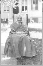 SA0119 - Portrait of an elderly Shaker woman sitting in a chair outside., Winterthur Shaker Photograph and Post Card Collection 1851 to 1921c